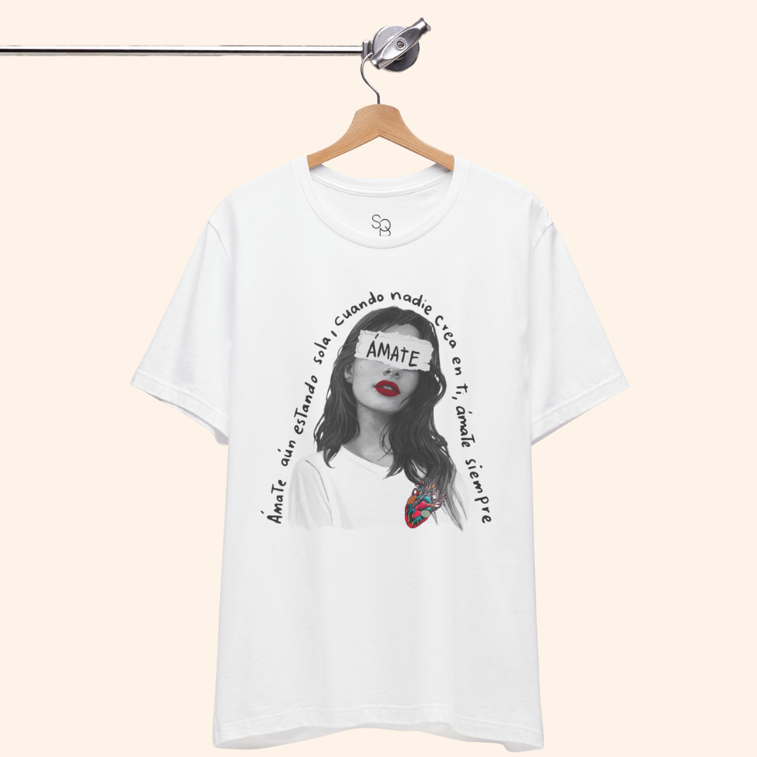 White Amate t-shirt displayed on wooden hanger against neutral background, showing front design and clean modern silhouette.