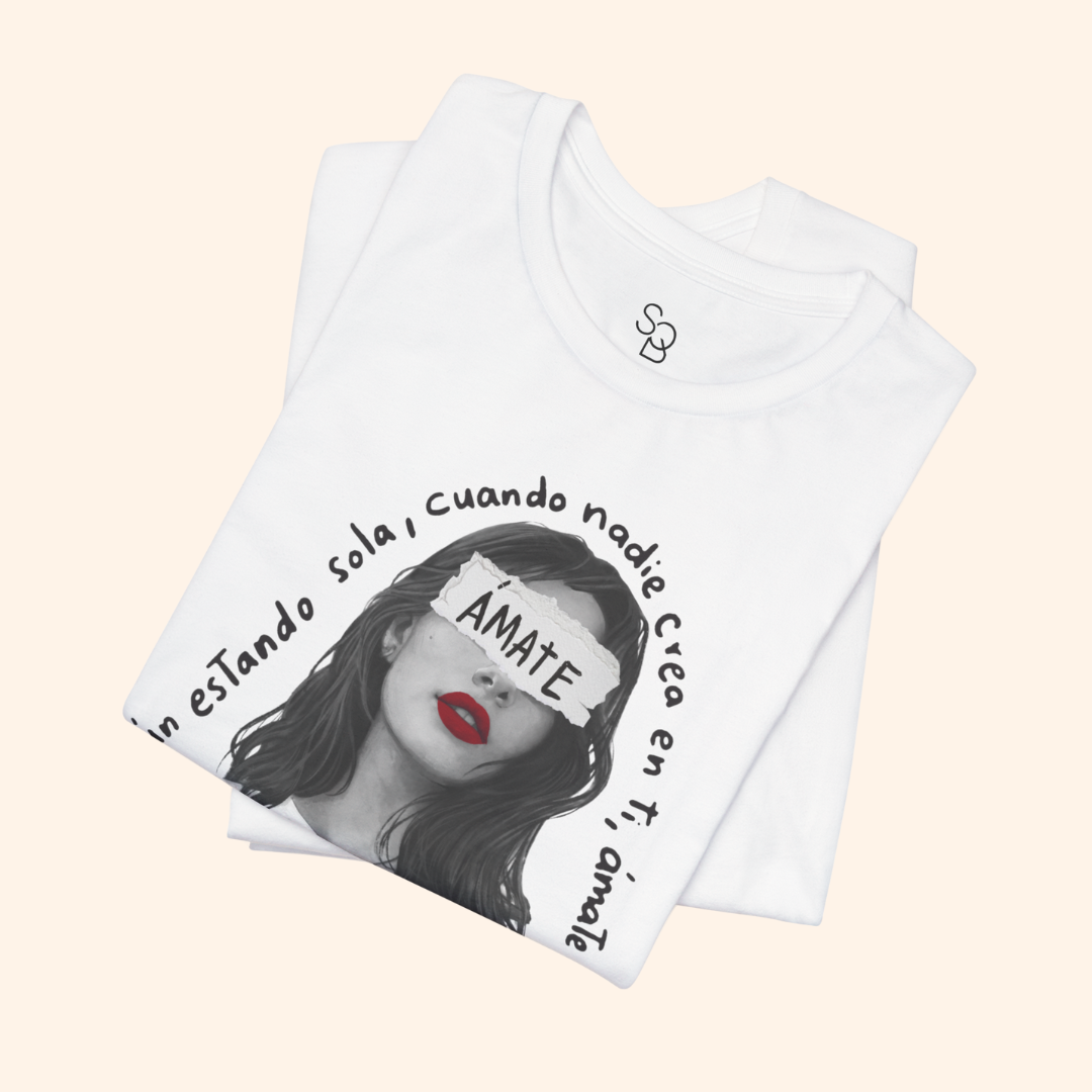 Folded white t-shirt showing partial Amate design with visible red lips and quote text, highlighting print quality and fabric softness.