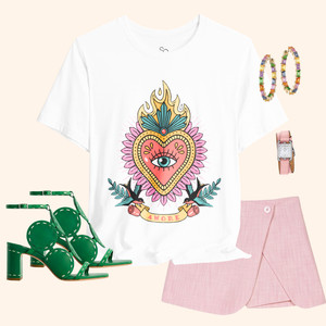 Styled outfit flat lay: white Amore graphic tee with pink mini skirt, green heeled sandals, hoop earrings, blush watch; chic street style set.