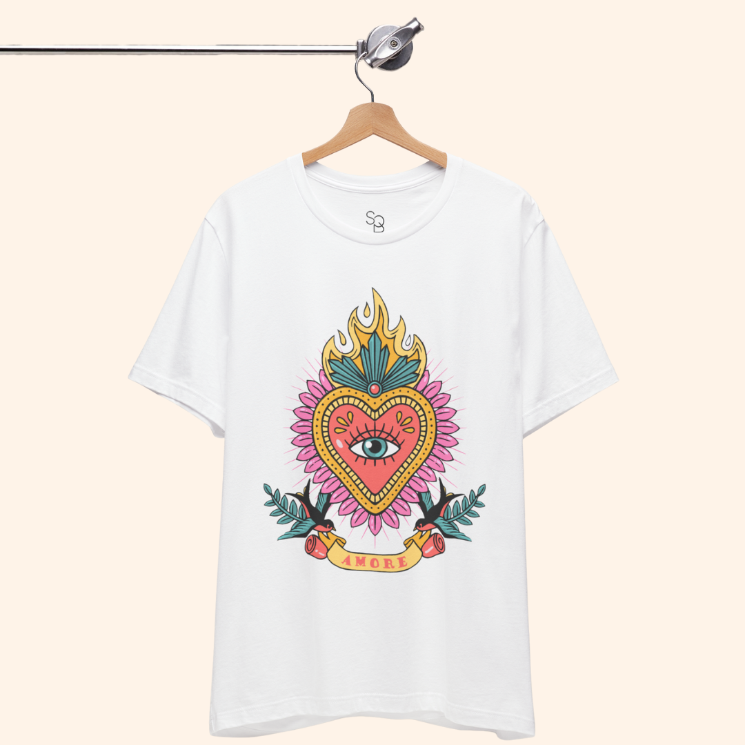 White Amore T-Shirt on hanger from metal rod, full sacred heart graphic visible; clean studio shot of unisex graphic t-shirt.