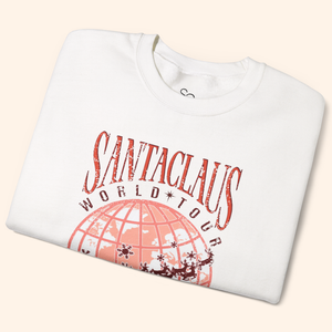 Folded white Santas World Tour sweatshirt showing vintage-style tour graphic with red world map and Santa’s sleigh, cozy cotton-poly fabric, holiday graphic sweatshirt detail.