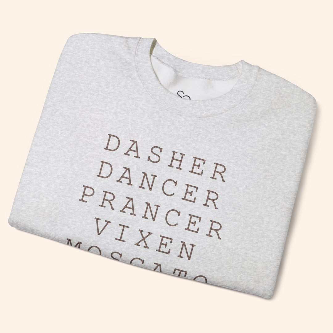 Heather gray Reindeer Fun sweatshirt folded on a beige backdrop, showing the ribbed collar and the top lines of the stacked black text; soft fleece texture and neat retail presentation.