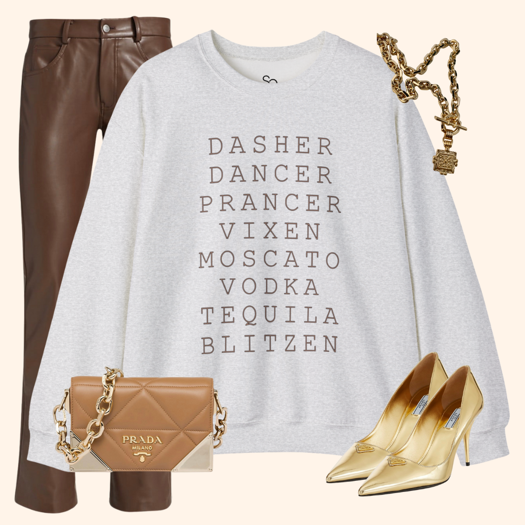 Styled flat lay featuring the gray Reindeer Fun sweatshirt with brown faux leather pants, gold pointed heels, a chunky gold chain necklace, and a tan quilted chain-strap mini bag; neutral background for chic holiday outfit inspiration.