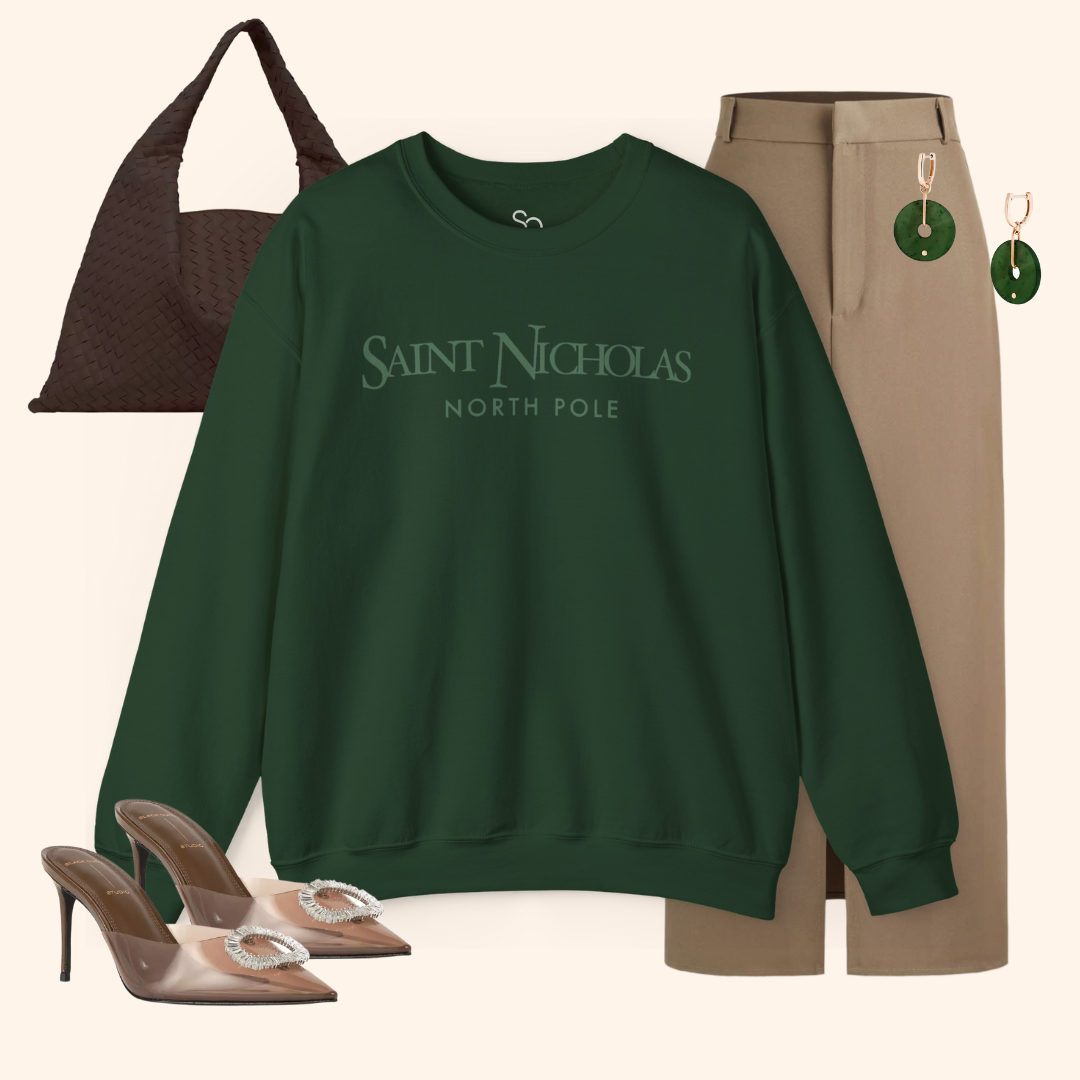 Saint Nicholas Christmas Sweatshirt styled with tan trousers, brown woven bag, and green earrings; elevated festive outfit inspiration.