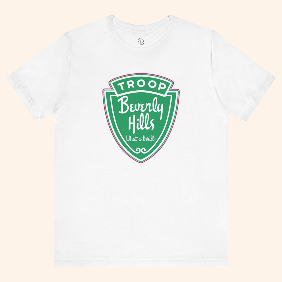 White Troops graphic tee styled in a minimal flat lay showing the front green badge print, casual streetwear look, soft cotton fabric.