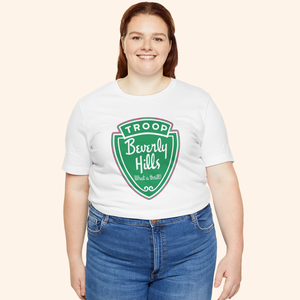 Plus size model wearing the Troops graphic tee in white cotton with green retro badge print, styled with jeans for a casual look.