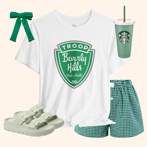 Troops T-Shirt styled with green gingham shorts, green hair bow, white sandals, and green tumbler for a playful retro outfit idea.