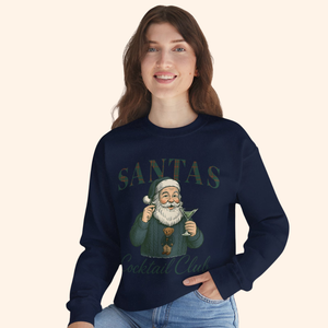 Woman wearing navy Santas Cocktail Club holiday sweatshirt with vintage Santa art and martini illustration, styled casually with light denim for a festive winter outfit.