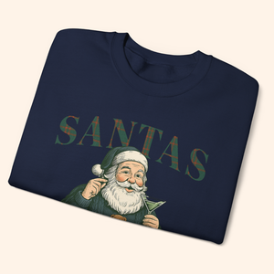 Navy Santas Cocktail Club holiday sweatshirt neatly folded to show vintage Santa art and plaid lettering, emphasizing giftable presentation and cozy fleece fabric.