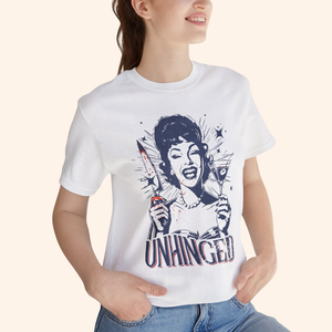 Model wearing the Unhinged T-Shirt with light wash denim, cropped close up of the torso to showcase how the dark humor graphic sits on the body, soft white cotton tee styled for everyday street style.