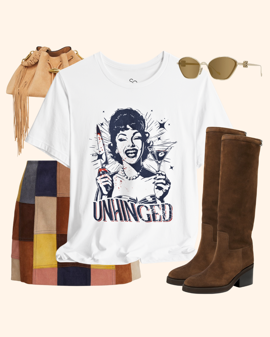 Styled flat lay of the Unhinged T-Shirt paired with a patchwork suede mini skirt, tall brown boots, fringe bucket bag, and sunglasses, creating a fall ready street style outfit that mixes retro housewife dark humor graphic tee with polished accessories.