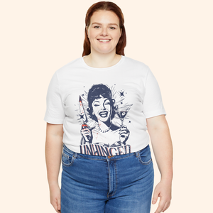 Plus size model smiling in the Unhinged T-Shirt styled with blue jeans, full front view that highlights inclusive sizing, comfortable fit, and bold retro housewife design, dark humor graphic tee for curvy bodies.