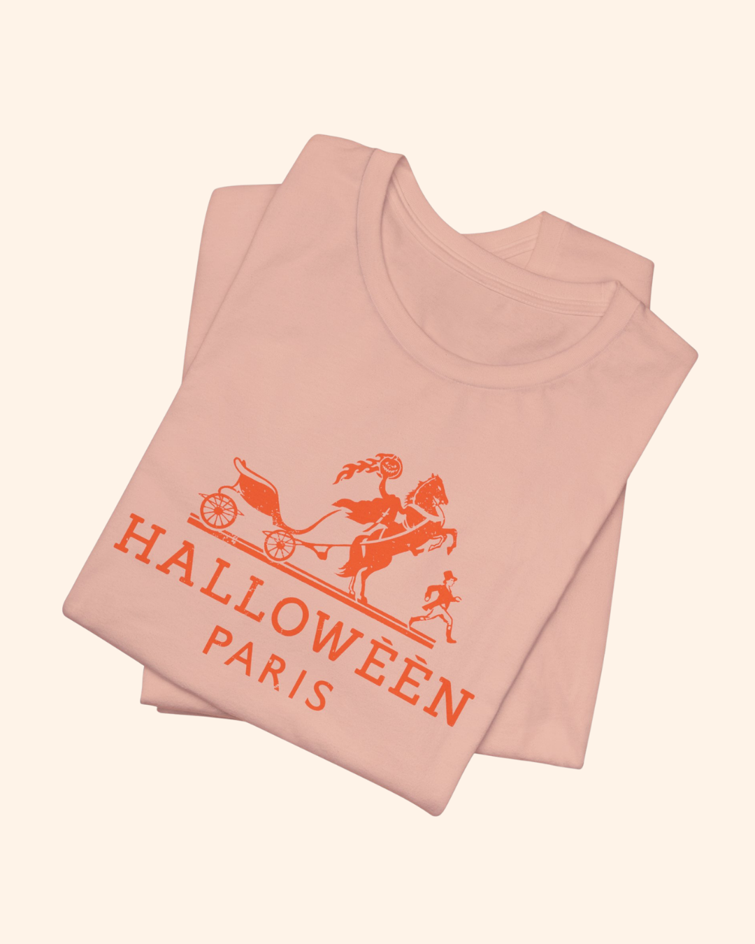 Folded peach Midnight in Paris graphic tee showing Halloween Paris lettering
