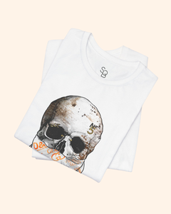 Folded white All or Nothing graphic tee with orange-accent bandana skull