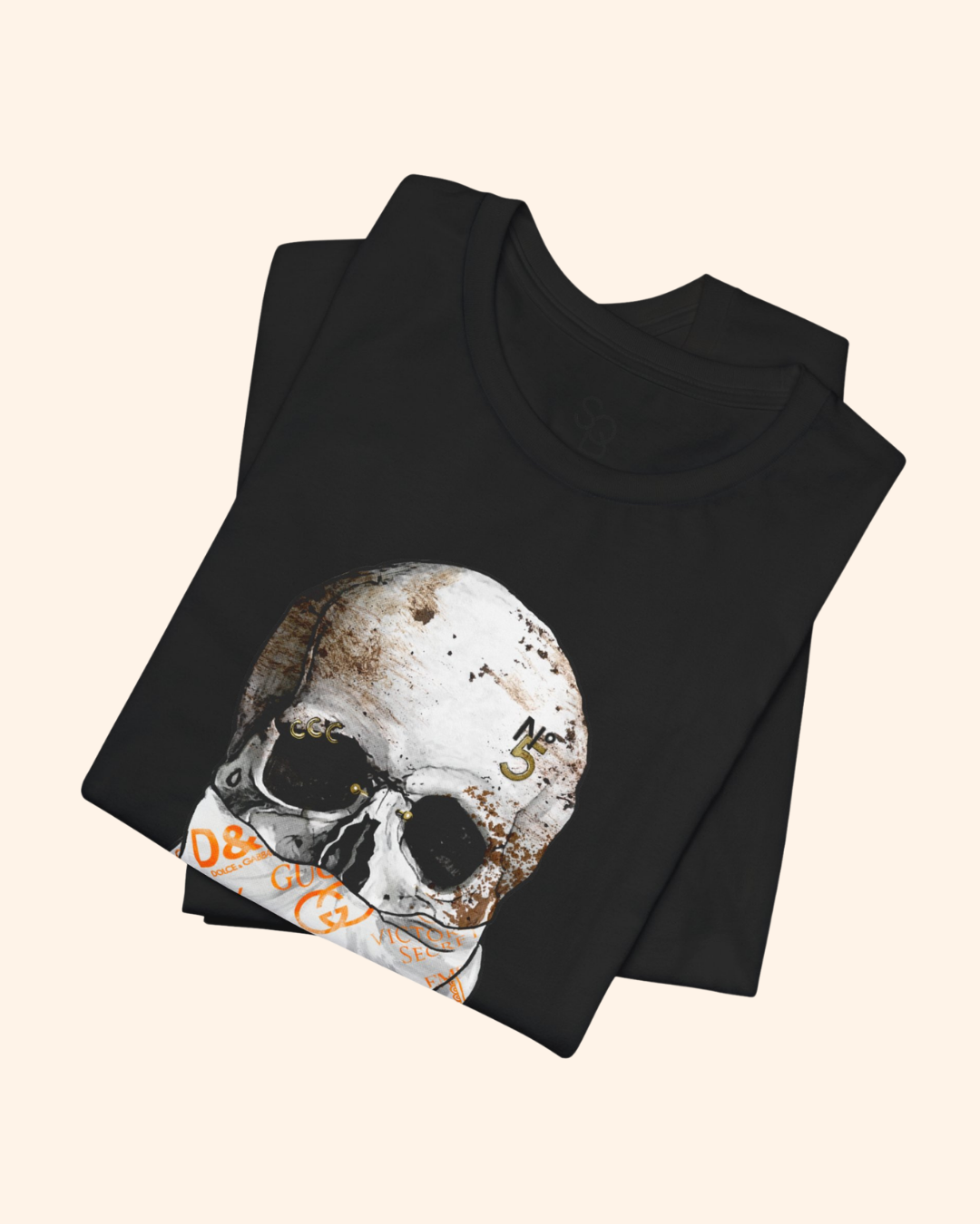 Folded black All or Nothing tee with weathered skull and patterned bandana artwork