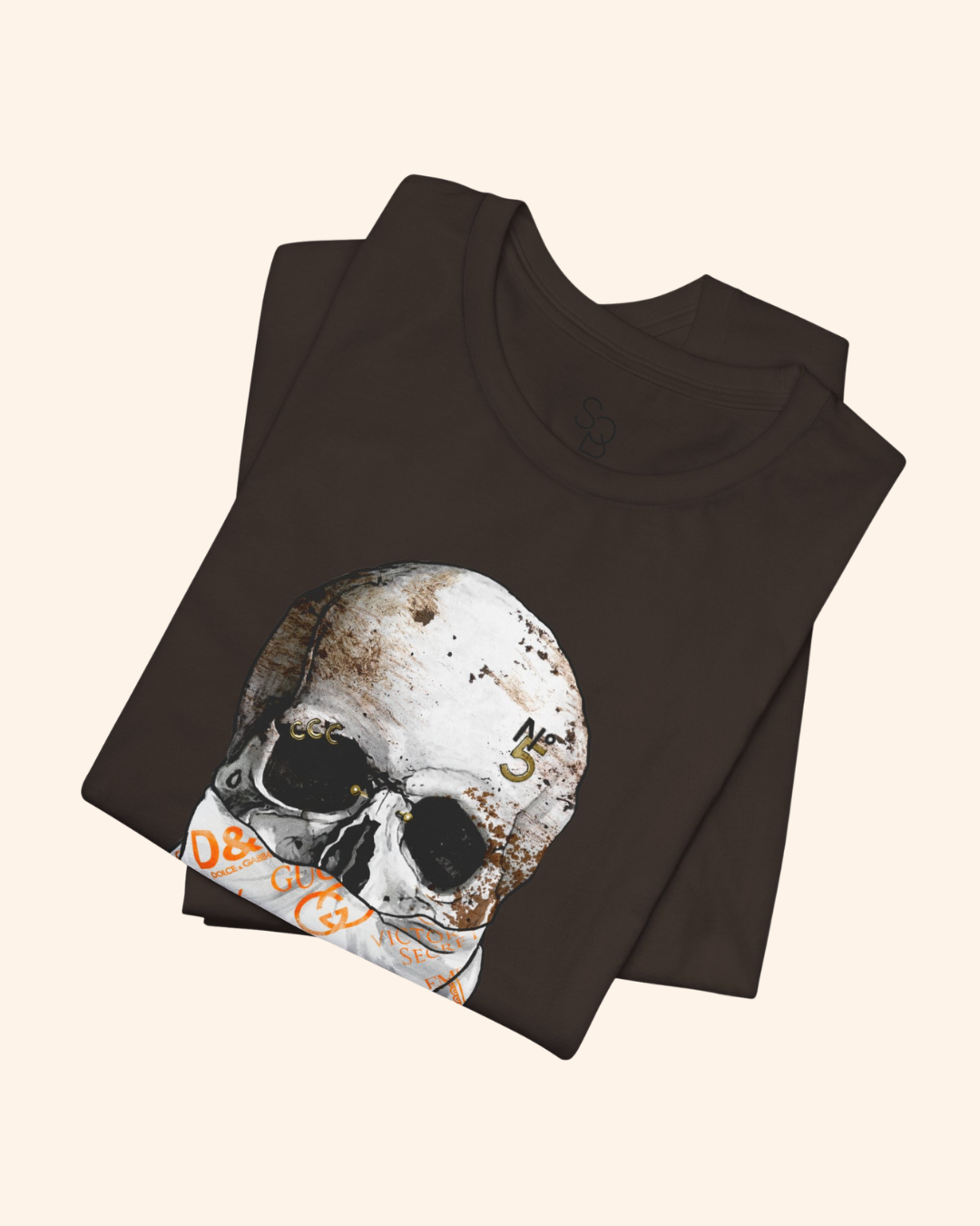Folded brown All or Nothing graphic tee showing the weathered skull artwork