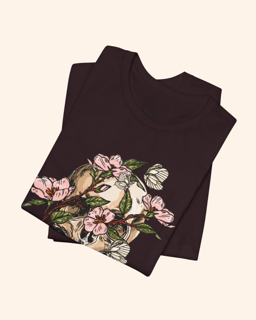 Folded Oxblood Black Spring With You tee showing the botanical skull artwork
