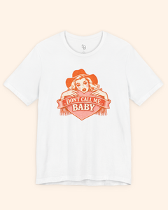 Flat lay of a white western graphic tee with orange heart artwork and Dont Call Me Baby lettering, styled clean and minimal for product detail.