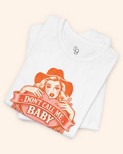 Folded white cotton graphic tee showing partial view of the orange western heart design and Dont Call Me Baby text.