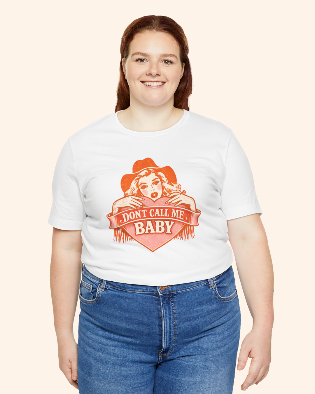 Plus size woman wearing white Don’t Call Me Baby cowgirl graphic tee, casual fit with jeans, front facing studio style image.