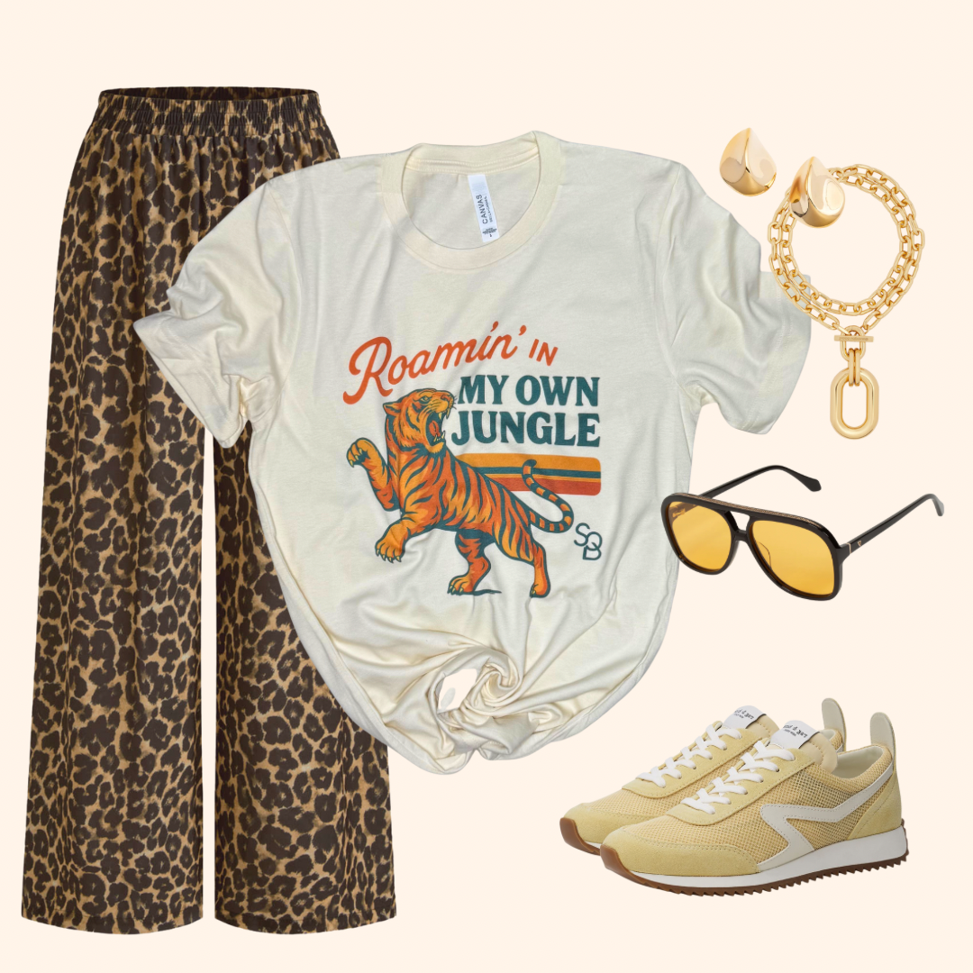 Tiger travel tee styled with leopard print pants, yellow sneakers, gold jewelry, and sunglasses for a casual travel outfit.

