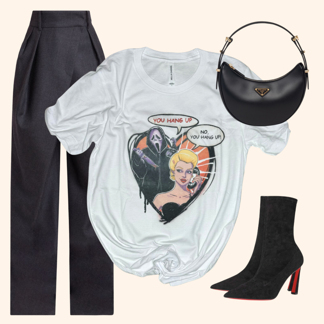 Hang Up Tee styled with tailored trousers, heeled boots, and a black crescent bag for a sleek Halloween horror-inspired streetwear look. Graphic features a retro blonde woman and masked slasher in a heart-shaped frame. Great for spooky season or edgy casual outfits. Soft poly-cotton feel. Unisex fit. Bella Canvas.
