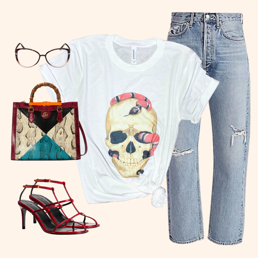 Flat lay skull snake graphic tee with jeans, red heels, and bag styled for night out