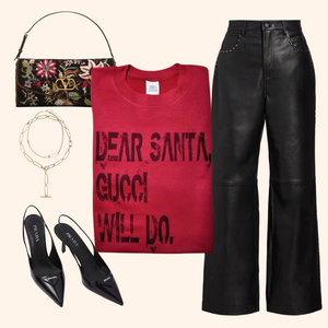 Flat lay featuring a red holiday sweatshirt, wide-leg black pants, black heels, floral purse, and gold jewelry for a festive outfit look.