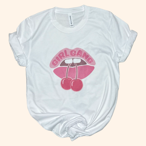Flat lay of white Girl Gang cherry lips tee, cotton graphic shirt for women and best friend gifting.