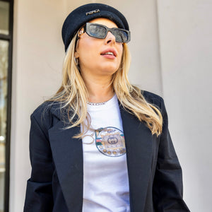Alt Text: Y2K aesthetic outfit with white graphic tee, black blazer, beige skirt, Fendi beret, and gold jewelry for streetwear fashion look.


