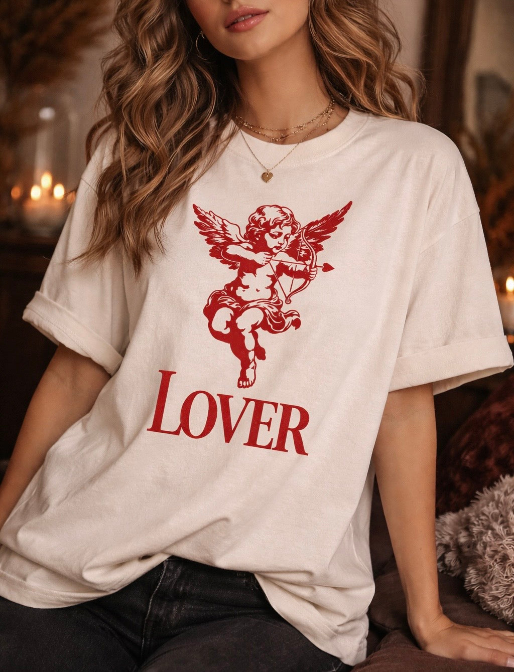 Model wearing a natural color graphic t shirt with red cherub cupid illustration and lover text, face cropped out to focus on the shirt.