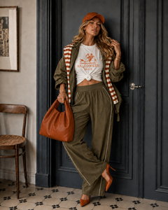 White Midnight in Paris Halloween tee styled with olive trousers, olive jacket, orange cap, orange bag and orange heels