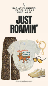 JUST ROAMIN’ tiger travel tee shown with product poster featuring phrase “Bad at planning. Excellent at winging it.”