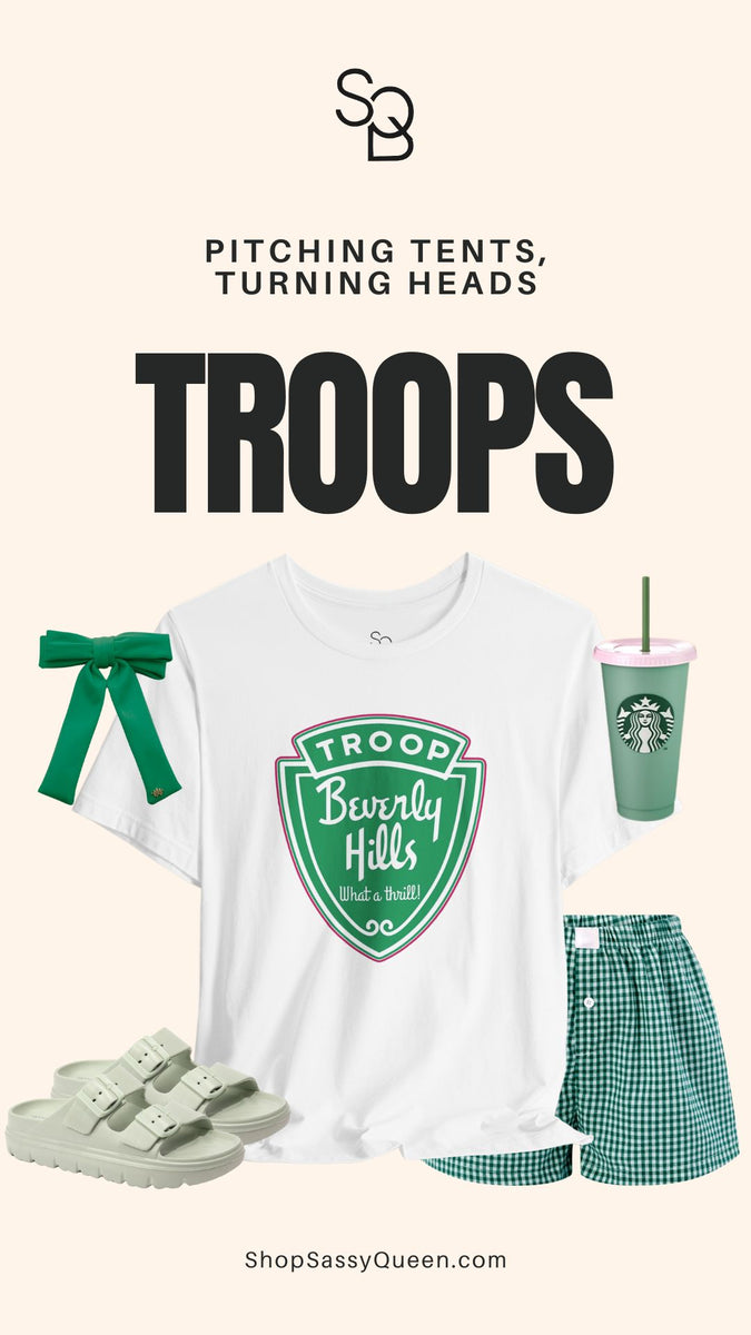 Troops T-Shirt displayed with green bow, green cup, shorts, and sandals with the phrase Pitching Tents Turning Heads.