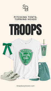 Troops T-Shirt displayed with green bow, green cup, shorts, and sandals with the phrase Pitching Tents Turning Heads.